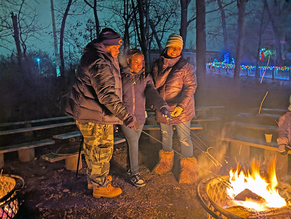 The Young family stayed warm by the fire at the Irons Oaks trail walk. (Chris Weber, H-F Chronicle)