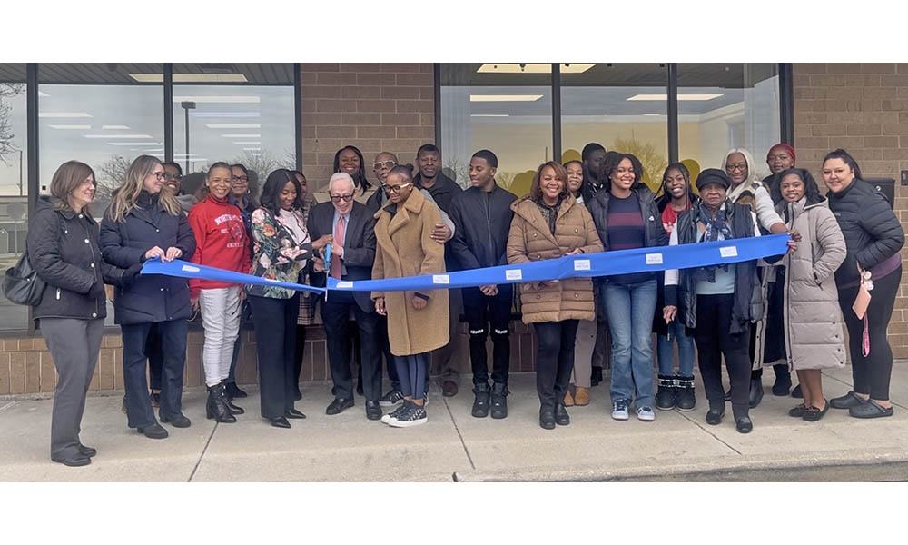 Little Hands owner Sharon Cooper and Homewood Mayor Rich Hofeld cut the blue ribbon with Little Hands staff, village officials and Cooper's friends and family, officially marking the opening of the daycare center. (Nick Ulanowski / H-F Chronicle)