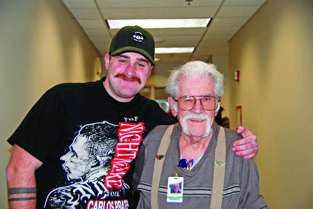 Nick Biasella, right, gets a hug from student Adam Kroll after a class at Prairie State College's EMT training session. Biasella, EMT program director, has been sharing his expertise with EMT students for more than 30 years. (Provided photo)