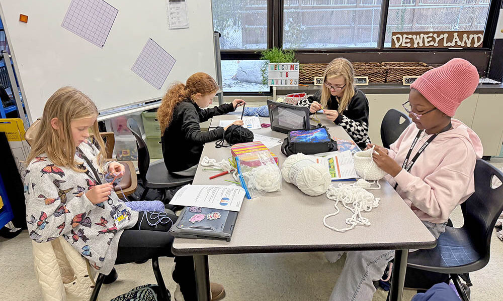 Members of the Parker Junior High Knitting and Crochet Club work on projects together. (Provided photo)