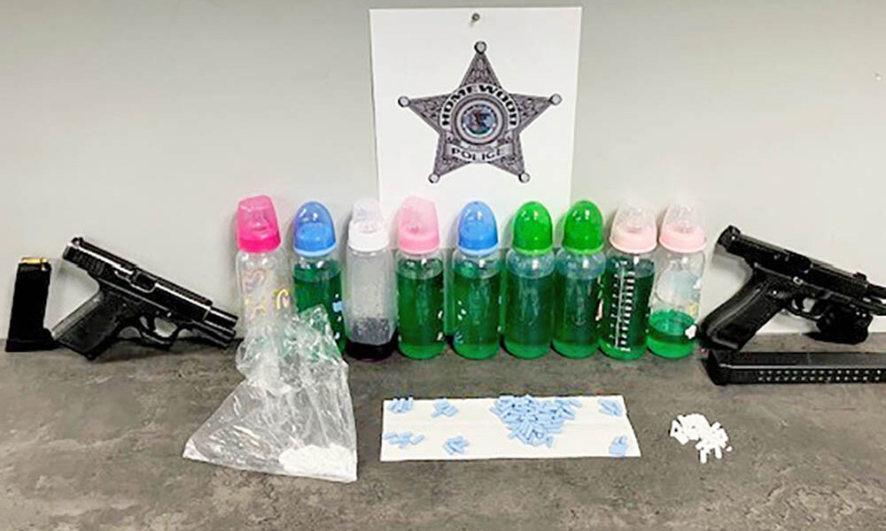 Homewood police released a photo showing items taken during an arrest on Halsted Street on Wednesday, including two handguns, pills and suspected narcotics contained in baby bottles. (Provided photo)