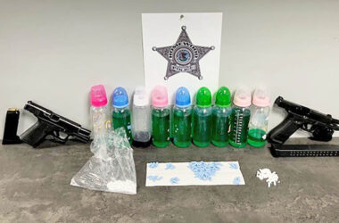 Homewood police released a photo showing items taken during an arrest on Halsted Street on Wednesday, including two handguns, pills and suspected narcotics contained in baby bottles. (Provided photo)