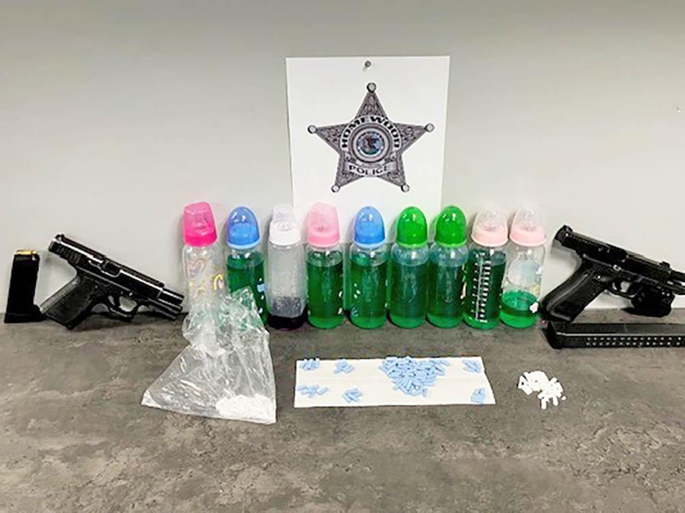 Homewood police released a photo showing items taken during an arrest on Halsted Street on Wednesday, including two handguns, pills and suspected narcotics contained in baby bottles. (Provided photo)
