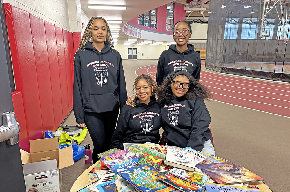Members of the Homewood-Flossmoor High National Honor Society volunteered to work at the Leaders Are Readers program hosted by the wrestling team. Working the event are, seated left, Adekemi Williamson, and at right, Erin Kirkwood; standing left is Jillian Monroe and at right, Kaci Figures. (Marilyn Thomas/H-F Chronicle)