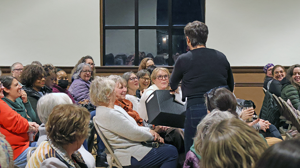 Carrie Bonanotte, standing, moves through the room as members of 100+ Women Who Care – South Suburbs prepare to vote during the Jan. 9 meeting in Flossmoor. (Nuha Abdessalam/H-F Chronicle)