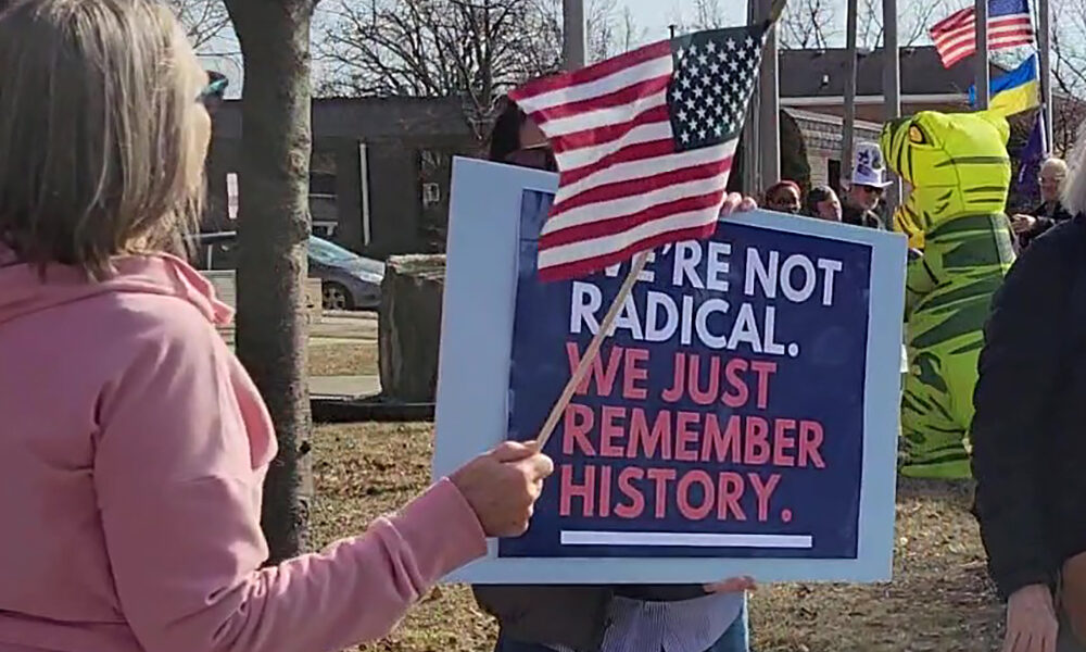 A participant at the ABT Presidents Day rally in Homewood holds a sign that reads, "We're not radical. We just remember history." (Eric Crump/H-F Chronicle)