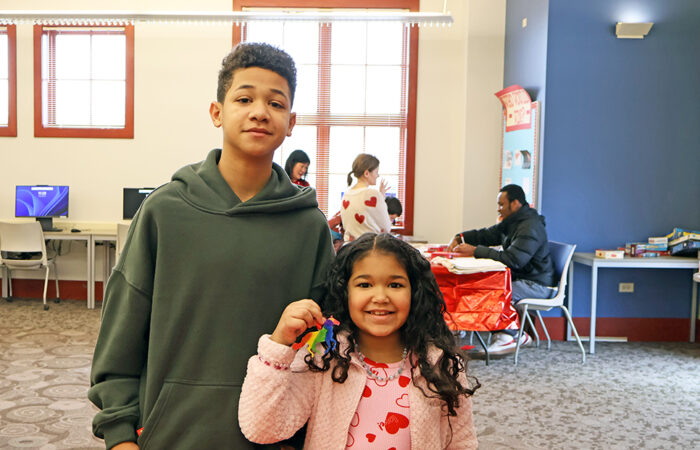 Langston Graham, 13, stands with his sister, Olivia Graham, 7, during the library’s Lunar New Year celebration. (Nuha Abdessalam/H-F Chronicle)
