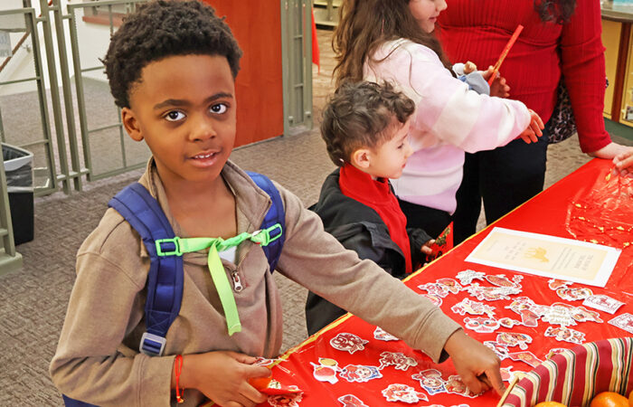 Jason Smith, 6, picks out stickers at a craft table during the Flossmoor Public Library’s Lunar New Year celebration. (Nuha Abdessalam/H-F Chronicle)