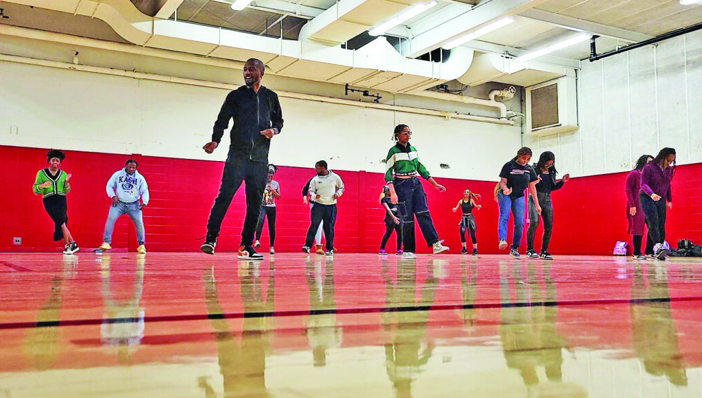 Jaron Boyd, foreground, demonstrates basic footwork steps during a workshop in 2024 at Homewood-Flossmoor High School. (Eric Crump/H-F Chronicle)