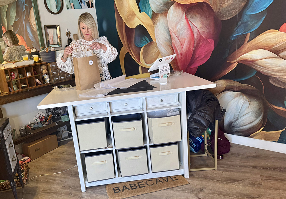 Gypsy Fix owner Morgan Sullins bags a customer purchase at her newly redecorated store. (Karen Torme Olson/H-F Chronicle)