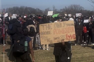 A Homewood-Flossmoor High School student with a sign that says "The only thing more powerful than hate is love," a reference to Bad Bunny's sign at the Super Bowl. (Nick Ulanowski/H-F Chronicle)
