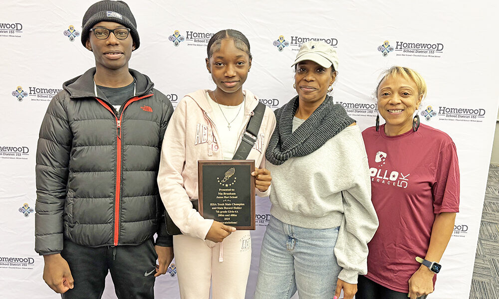 Nia Branham, second from left, an eighth grader at Hart School, holds her latest trophy. She set state records in the 200-meter and 400-meter races for the Illinois Elementary School Association competition. With her are, from left, her brother Nicholas, her mother Nona Branham and her cousin Annette Burke. (Marilyn Thoams/H-F Chronicle)