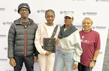 Nia Branham, second from left, an eighth grader at Hart School, holds her latest trophy. She set state records in the 200-meter and 400-meter races for the Illinois Elementary School Association competition. With her are, from left, her brother Nicholas, her mother Nona Branham and her cousin Annette Burke. (Marilyn Thoams/H-F Chronicle)