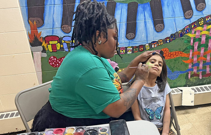 Joshay Carr paints Rebekah Burgos’ face during the Churchill School Black History Month Event on Feb. 26. (Nick Ulanowski H-F Chronicle)