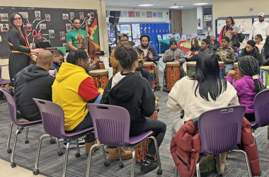 Teacher Jon Pettis, in the tan jacket, leads the drum circle at the Churchill School Black History month event on Feb. 26. Orchestra teacher Bryson Robinson-Levant and Churchill Elementary parent Laura Miller play instruments behind him. (Nick Ulanowski H-F Chronicle)