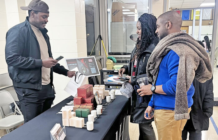 Will Elmore and Dori Elmore buy candles from Mahogany House Candles co-owner Drew Osifalujo during the Churchill School Black History Month event. (Nick Ulanowski H-F Chronicle)