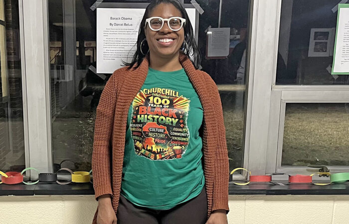 Churchill Elementary Dean of Students Nakia Norman stands in front of a student’s poster about Barack Obama during the school's Black History Month event on Feb. 26. (Nick Ulanowski H-F Chronicle)