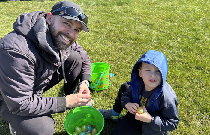 Eric Comiskey helps his son, Gavin, 4, look through his egg collection in hopes of finding the golden ticket for a special prize. (Marilyn Thomas/H-F Chronicle)