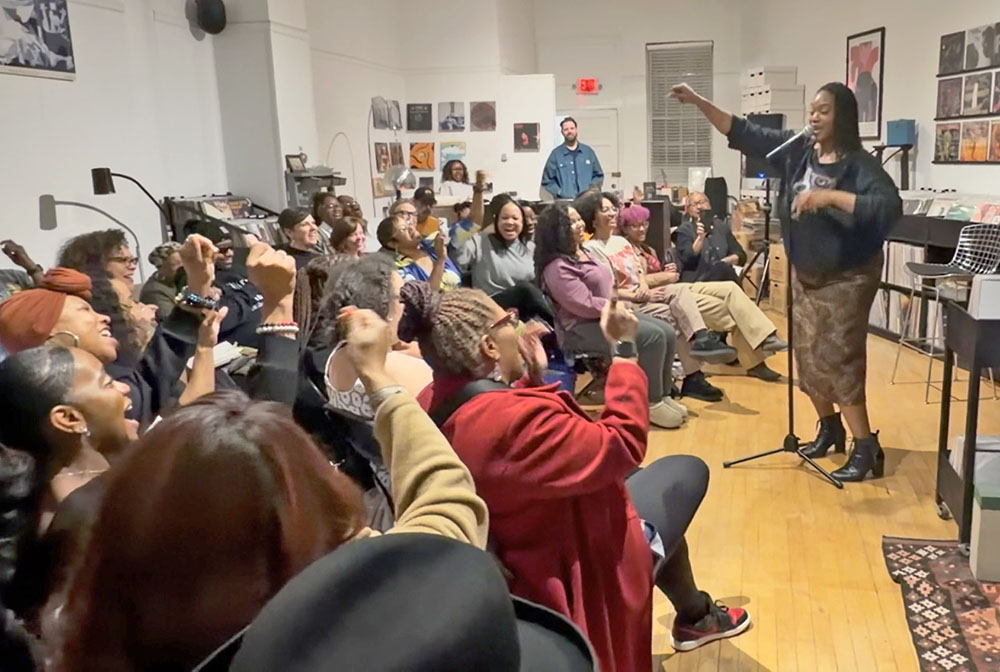 Theresa tha S.O.N.G.B.I.R.D. performs a song-poem hybrid and audience members singing along to the refrain, “All that Black Girl Magic.” (Nick Ulanowski / H-F Chronicle)