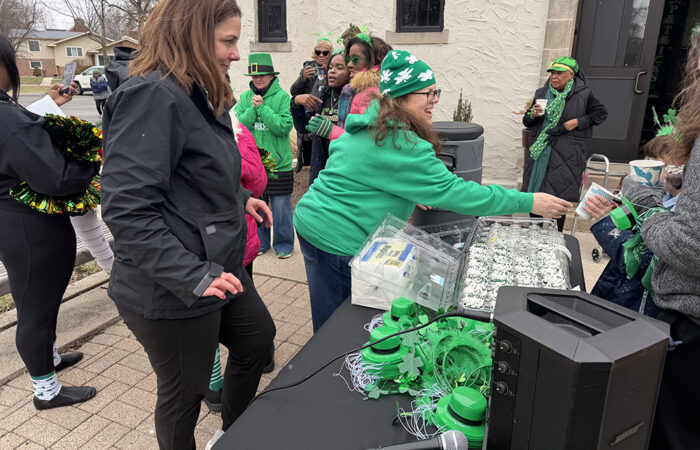 Flossmoor Community Engagement Manager Stephanie Wright, left, gives out hot chocolate to community members with neighborhood liaison Vicki Stevenson, right, after the St. Patrick's Day Parade. (Nick Ulanowski / H-F Chronicle)