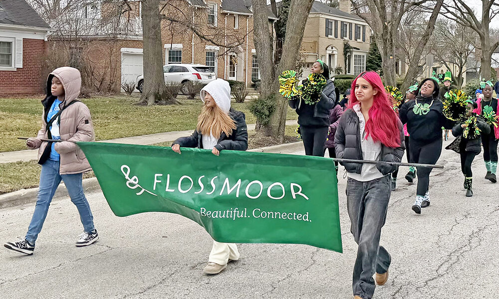 Youth performers from the Chicago Southland Cheerettes & Cheeros lead the St. Patrick's Day Parade on March 14, carrying a sign that says "Flossmoor: Welcoming. Beautiful. Connected." (Nick Ulanowski / H-F Chronicle)