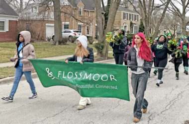 Youth performers from the Chicago Southland Cheerettes & Cheeros lead the St. Patrick's Day Parade on March 14, carrying a sign that says "Flossmoor: Welcoming. Beautiful. Connected." (Nick Ulanowski / H-F Chronicle)