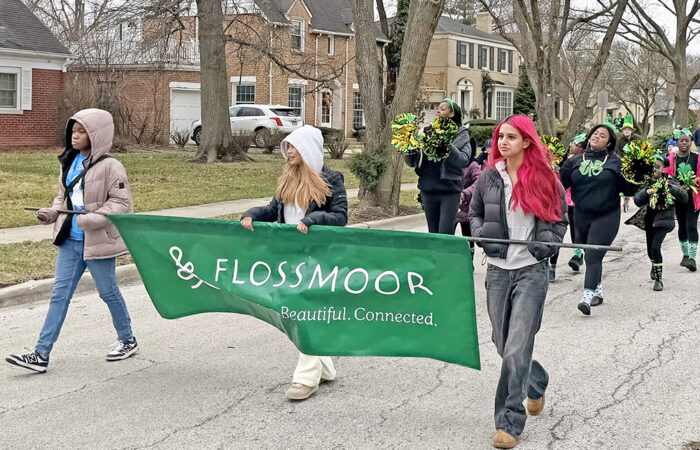 Youth performers from the Chicago Southland Cheerettes & Cheeros lead the St. Patrick's Day Parade on March 14, carrying a sign that says "Flossmoor: Welcoming. Beautiful. Connected." (Nick Ulanowski / H-F Chronicle)
