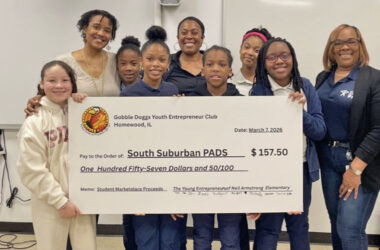 Neal Armstrong Elementary student Skylar Petritch, far left, Neal Armstrong Elementary teacher Latasha Davis, students Treasure House and Michelle Banjo, Gobble Dogs owner Annah Mitchell, students Cornelius Crossley Jr., Kaitlyn Perkins, Nia Greene and South Suburban PAD Shelter Operations Manager Rashida Hughes holding up the $157.50 check that the students donated to South Suburban PADS after a two-month entrepreneurship program and selling the products they made. (Provided photo)