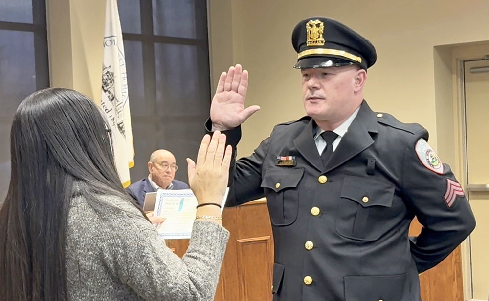 Det. James Strayer takes the oath office for his promotion to sergeant for the Homewood Police Department at the March 24 village board meeting. (Summer Kiswani/H-F Chronicle)
