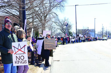 The line of protesters stretches along both sides of Harwood Avenue with people holding signs the whole way during the No Kings rally on March 28. (Nuha Abdessalam/H-F Chronicle)