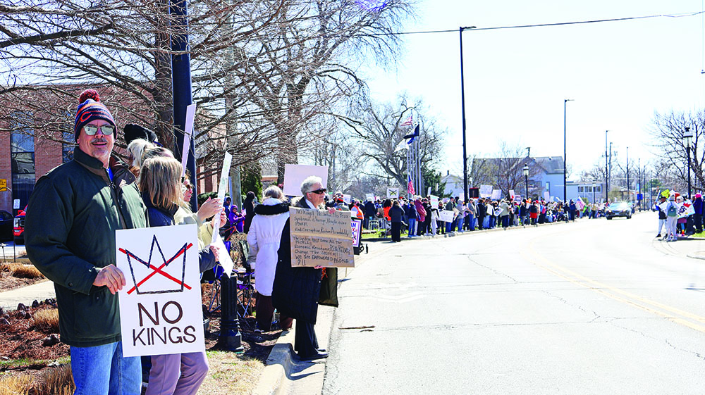 The line of protesters stretches along both sides of Harwood Avenue with people holding signs the whole way during the No Kings rally on March 28. (Nuha Abdessalam/H-F Chronicle)