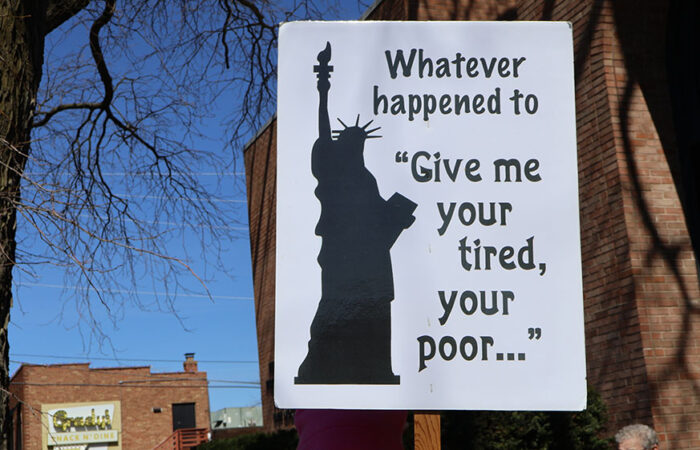 A sign reading “Whatever happened to ‘Give me your tired, your poor’” stands out among the crowd during Saturday’s rally in Homewood. (Nuha Abdessalam/H-F Chronicle)