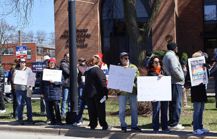 People line Harwood Avenue shoulder to shoulder, holding handmade messages as the crowd stretches past the Homewood Professional Building. (Nuha Abdessalam/H-F Chronicle)