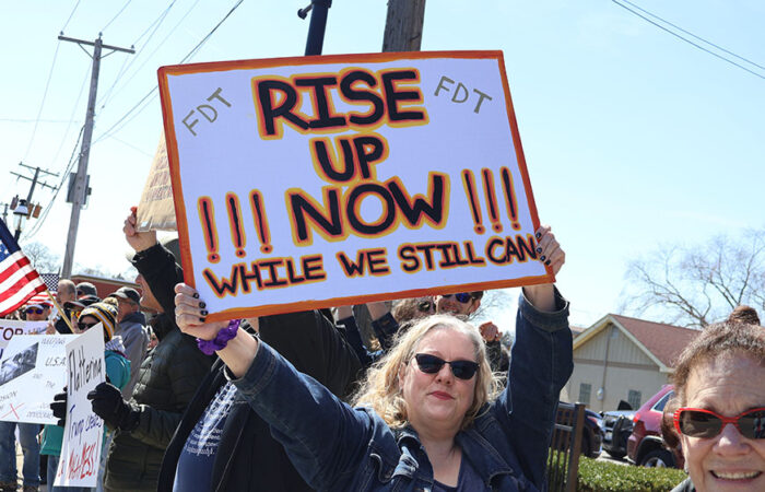 A participant in the No Kings rally in Homewood on March 28 holds a sign that reads, "Rise Up Now while we still can." (Nuha Abdessalam/H-F Chronicle)