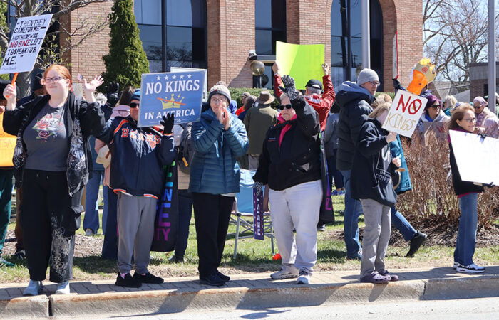 Protesters wave at passing vehicles during the No Kings rally on March 28 in Homewood. (Nuha Abdessalam/H-F Chronicle)