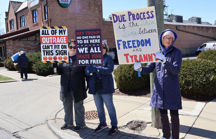 Mary Ellen Brabec, right, stands at the corner with others, holding her sign during the No Kings rally in Homewood on March 28. (Nuha Abdessalam/H-F Chronicle)