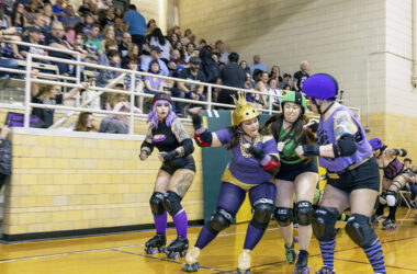A member of the Punk Rock Punishers, in purple, elbows a skater from the Horrific Haunters, in green, during a roller derby bout in front of a sell-out crowd at H-F Auditorium on Saturday, April 15. The event was organized by Chicago Knockouts Roller Derby, which hosts monthly bouts at the Homewood venue. (Colin Thomas/Thomas Photographic Services)