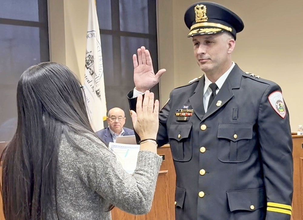 Sgt. Steven Brandenburger taking the oath of office for his promotion to deputy chief of police for the Homewood Police Department at the March 24 village board meeting. (Summer Kiswani/H-F Chronicle)