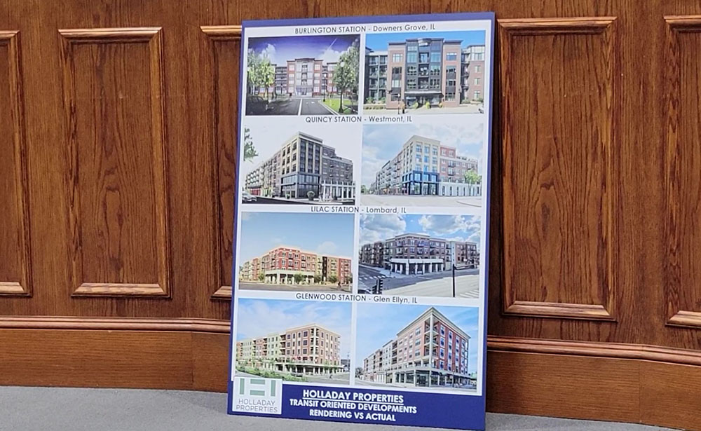 A poster showing Holladay Properties projects in Downers Grove, Westmont, Lombard and Glen Ellyn leans against the dais at the March 10 Homewood board meeting. Trustees cited Holladay's track record with TOD development projects as the reason they selected the company over its competitors. (Eric Crump/H-F Chronicle)