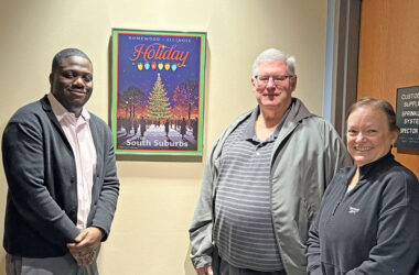 Homewood Assistant Village Manager Terence Acquah, left, with the artist of the Homewood Holiday Lights poster, Terrence Meehan, and Meehan's wife at village hall. (Summer Kiswani/H-F Chronicle)