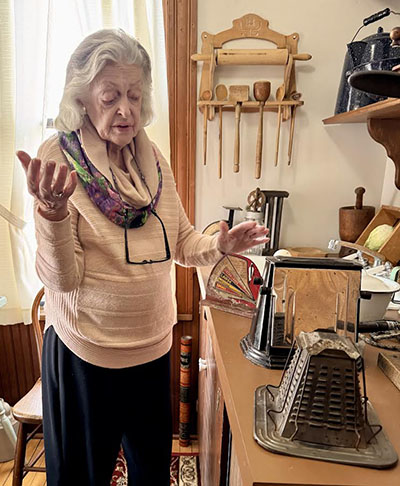 Elaine Egdorf shows of a cabinet filled with vintage spice and soap containers from products used in the early 19th century. (Karen Torme Olson)