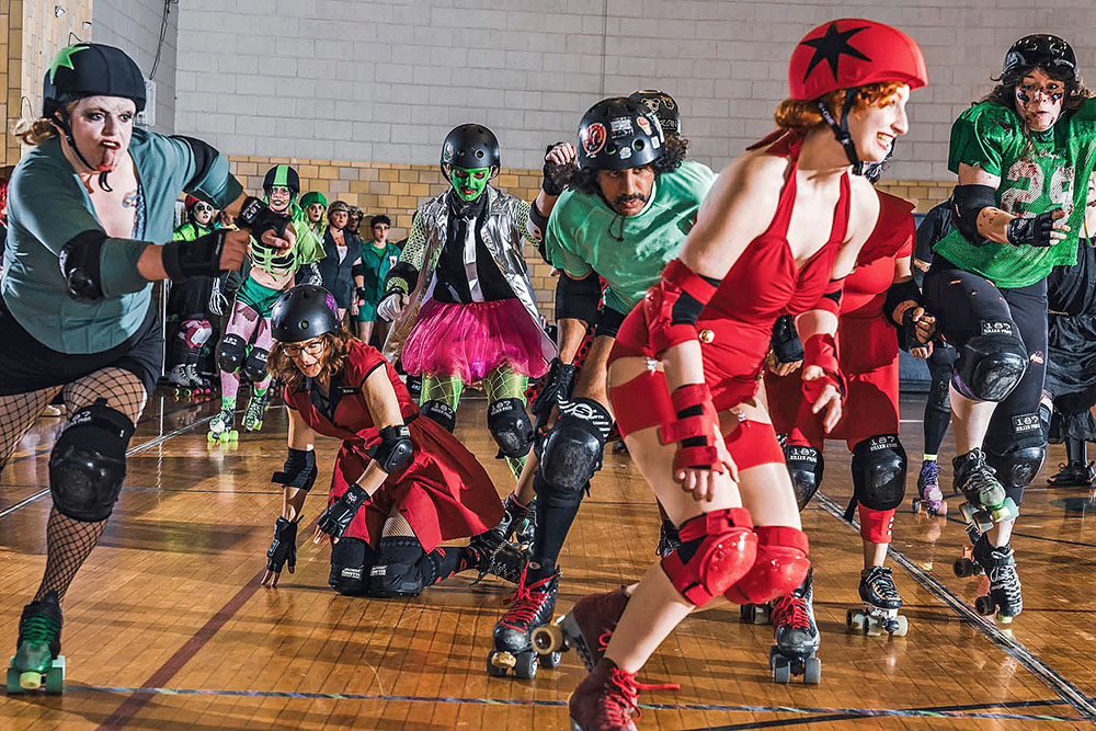 Ash Mateja, foreground, also known as the Crimson Vixen, dressed in all red and playing roller derby at the Homewood Auditorium. (Provided photo)