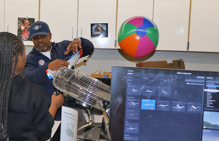 A presenter demonstrates airflow using a fan and a beach ball during a physics activity at the Girls STEAM Celebration at Homewood-Flossmoor High School on April 11. (Nuha Abdessalam/H-F Chronicle)