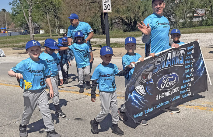 The Homewood Sharks, sponsored by Ford of Homewood, march in the April 25 opening day parade. (Nick Ulanowski/H-F Chronicle)