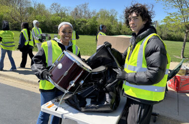Homewood-Flossmoor High School students Laila Dyer, left, and Bennett Matthys, handled a donated drum set for the organization Helping Hands. (Marilyn Thomas/H-F Chronicle)
