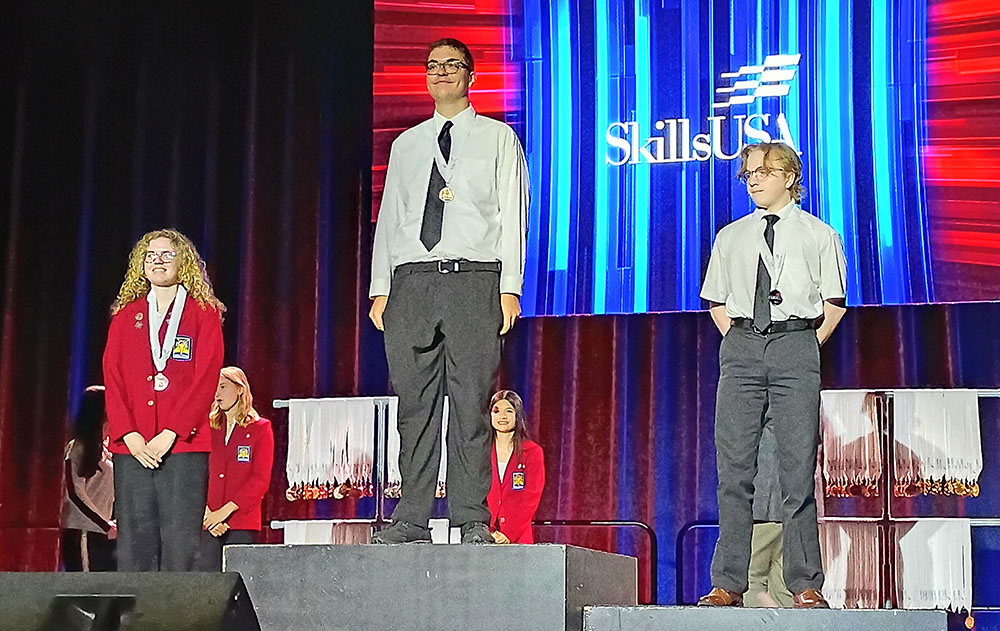 Charley Dieringer, a senior at Homewood-Flossmoor High School, stands on the top podium after winning first place in two competitions at SkillsUSA Illinois. (Provided photo)