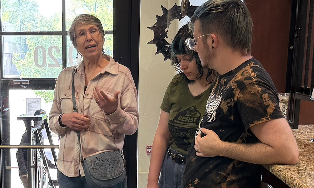 Jodi Libretti makes a case for restoring Pride flags in downtown Homewood while residents Carlie Rummel, center, and Sam Rummel, right, look on. Libretti brought the issue up at a recent village board meeting. (Nick Ulanowski / H-F Chronicle)