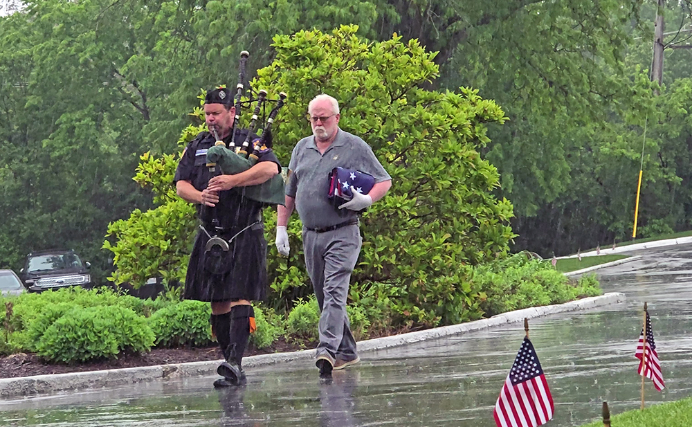 Pat McCool, right, delivers the American Flag escorted by a bagpiper during the Idlewild Country Club Memorial Day flag raising ceremony. (Eric Crump/H-F Chronicle)