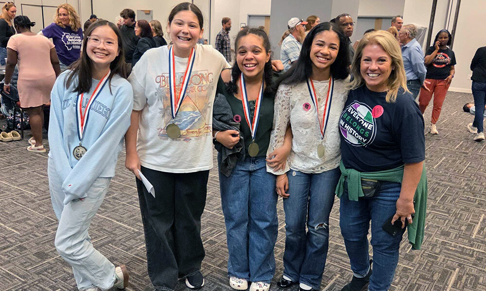 The Illinois History Day first place team from Parker Junior High show off their medals, from left, Avery Cheung, Emma Santiago, Dahlia Thomas and Sophie Folaju with their teacher Linda O’Dwyer. the team will next compete for a national title. (Provided photo)