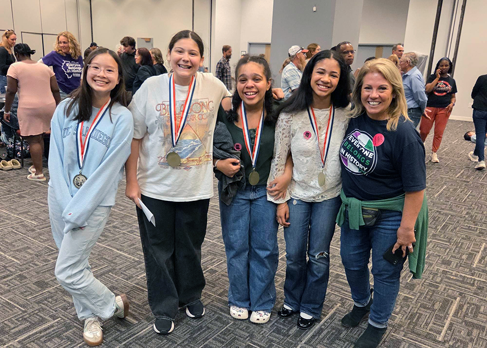 The Illinois History Day first place team from Parker Junior High show off their medals, from left, Avery Cheung, Emma Santiago, Dahlia Thomas and Sophie Folaju with their teacher Linda O’Dwyer. the team will next compete for a national title. (Provided photo)